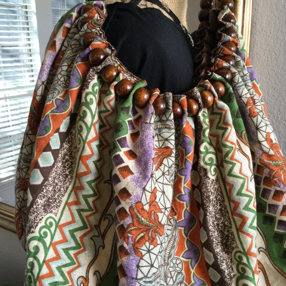 Reversible hobo tote with brown wood balls straps. Has a tie strap closu…